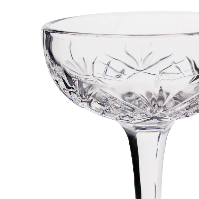 Close-up of a clear glass with intricate cut patterns on a white background