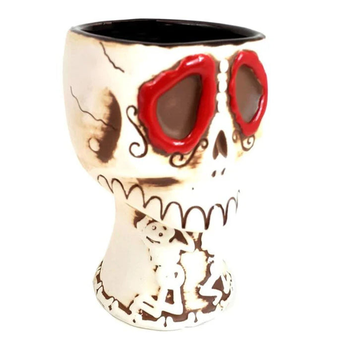 Skull-shaped mug with red eyes on a white background