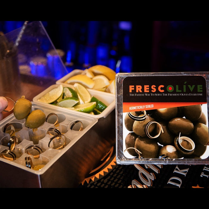 Frescolive olive packaging with olives and lemons on a bar counter