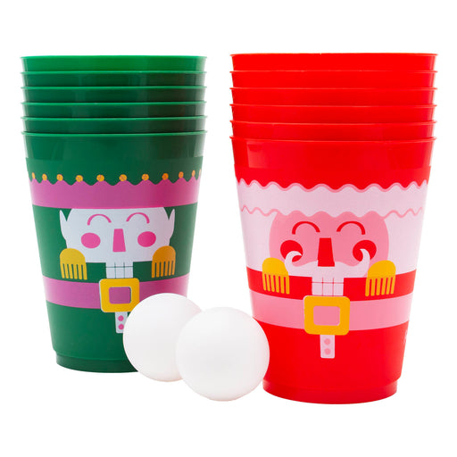 Green and red plastic cups with festive designs and two white balls on a white background