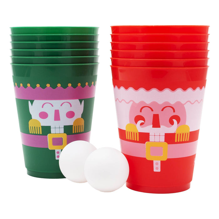 Green and red plastic cups with festive designs and two white balls on a white background