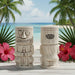 Two tiki mugs with a beach and palm trees in the background