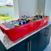 Red outdoor cooler with drinks on a patio with water view