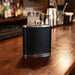 Black leather flask on a bar counter with blurred bar background