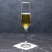 Champagne flute with golden liquid on a dark marble surface