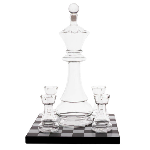 Clear glass chess-piece-shaped decanter with four matching small glasses, displayed on a black-and-white checkered base against a white background.