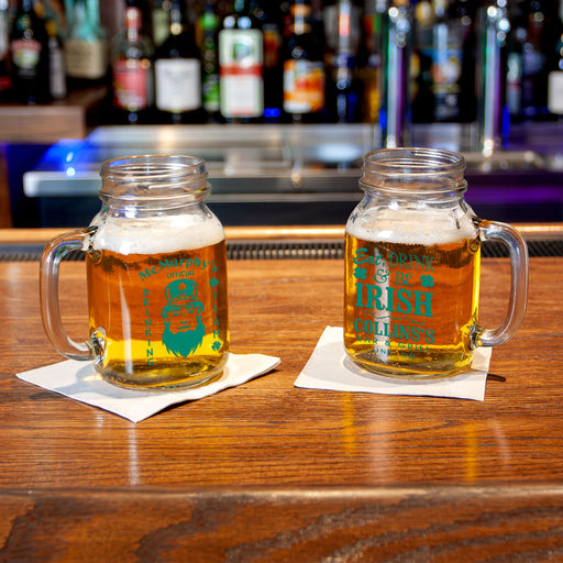 Two mason jars with beer on a bar counter, featuring 'Collins's' branding.