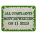 Metal sign with decorative border and text 'All complaints must be written on $1 bills' on a white background