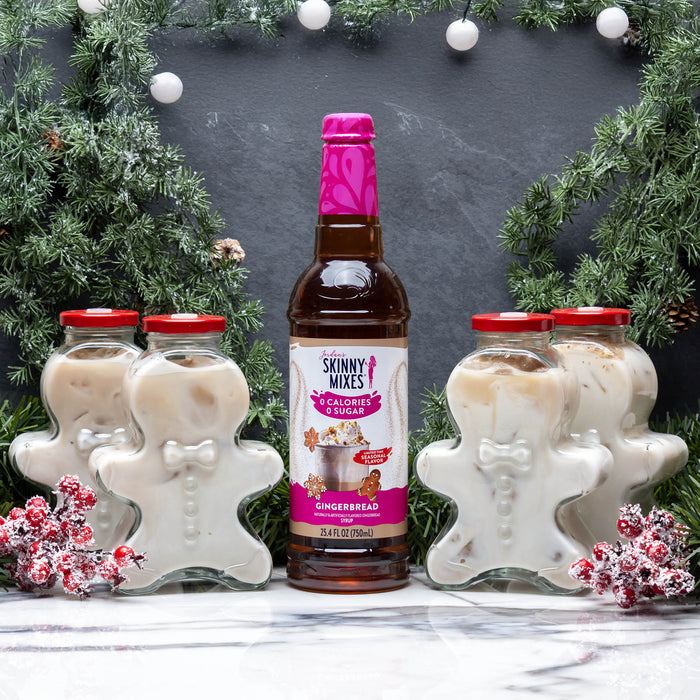 Bottle of Skinny Mixes gingerbread syrup with gingerbread man-shaped containers in a festive setting.