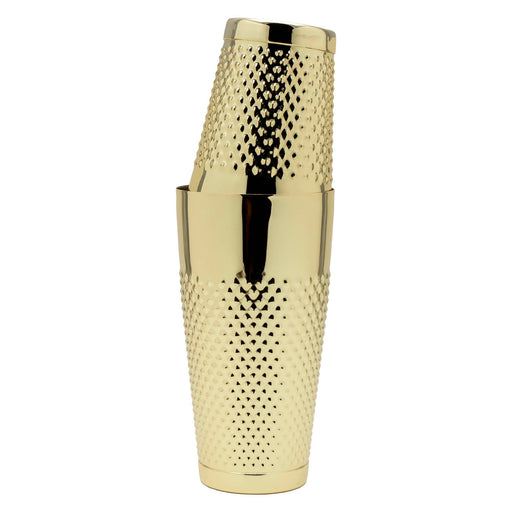 A polished gold cocktail shaker with a textured, diamond-patterned body, shown stacked with a matching gold lid on a plain white background.