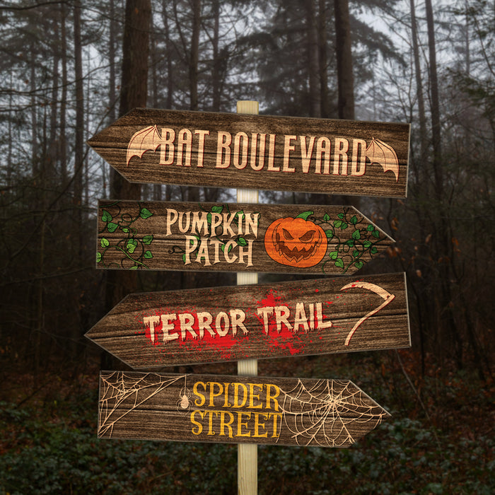 Wooden directional sign with Halloween-themed text in a forest setting