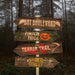 Wooden directional sign with Halloween-themed text in a forest setting