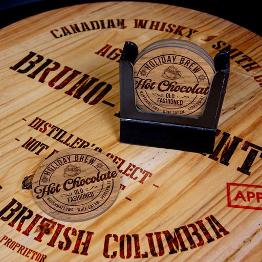 Coasters with 'Holiday Brew Hot Chocolate' design on a wooden surface with text.
