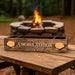 Wooden sign labeled 'S'mores Station' with a campfire in the background