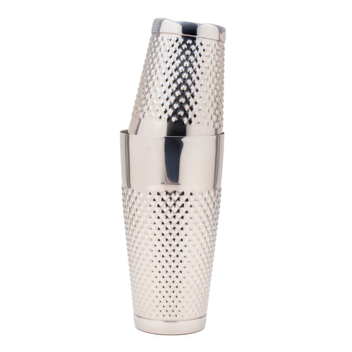 A stainless steel cocktail shaker with a textured, diamond-patterned metal body and a matching lid, shown stacked on a solid white background.