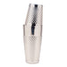 A stainless steel cocktail shaker with a textured, diamond-patterned metal body and a matching lid, shown stacked on a solid white background.
